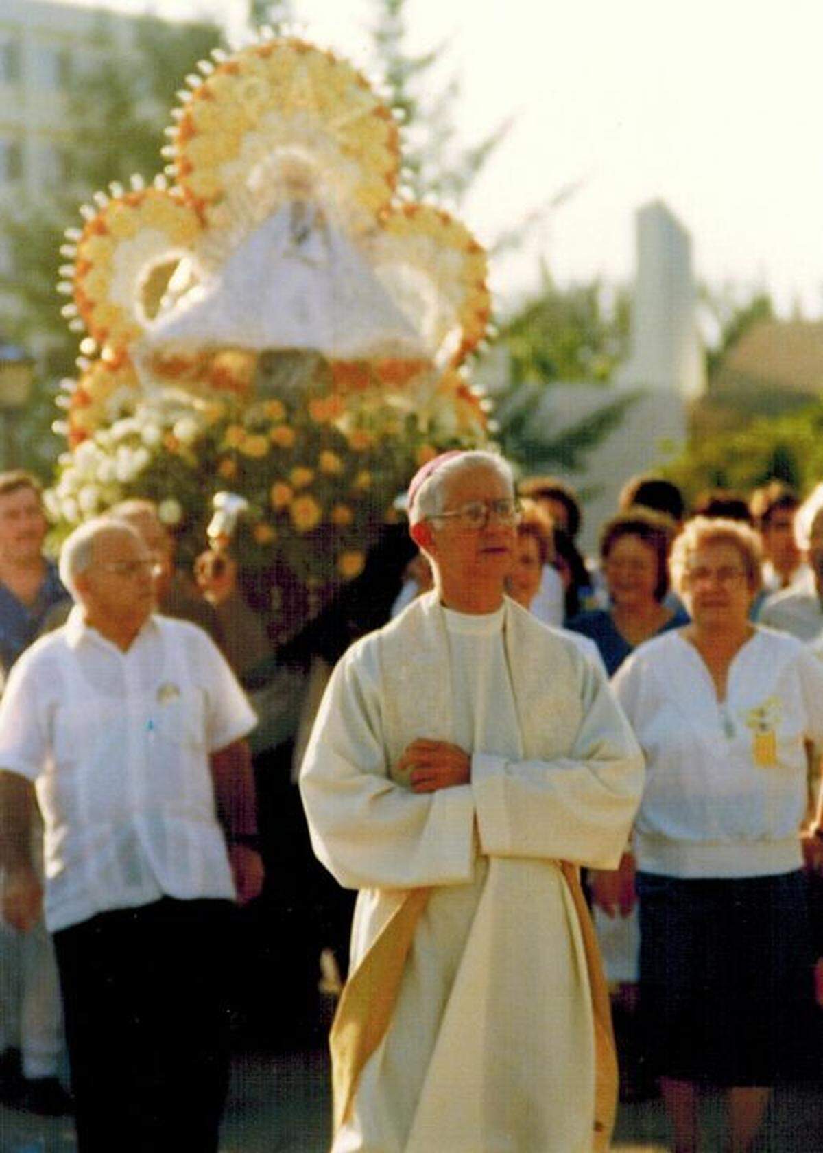 Georgina Nieto at the right of Bishop Agustín Román in a procession for the 25th anniversary of the Confraternity of Our Lady of Charity with the image of the Virgin.