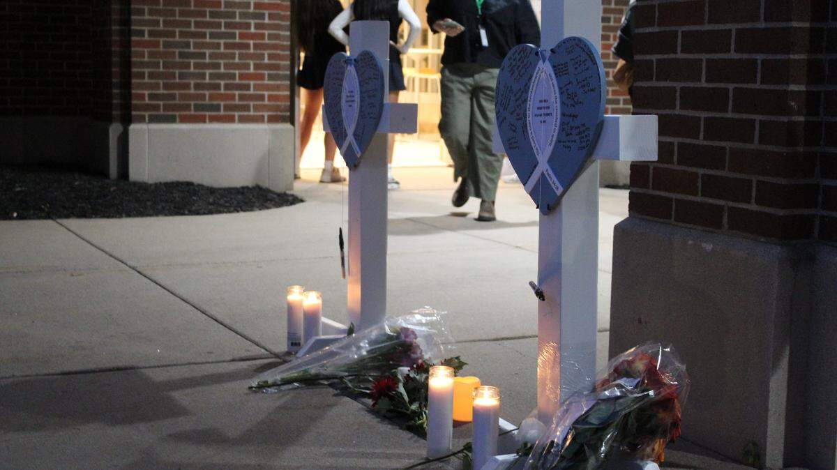 Asistentes a la vigilia escribieron mensajes en cruces por los dos niños que murieron en el tiroteo del 27 de agosto en la Iglesia de la Anunciación en Minneapolis.