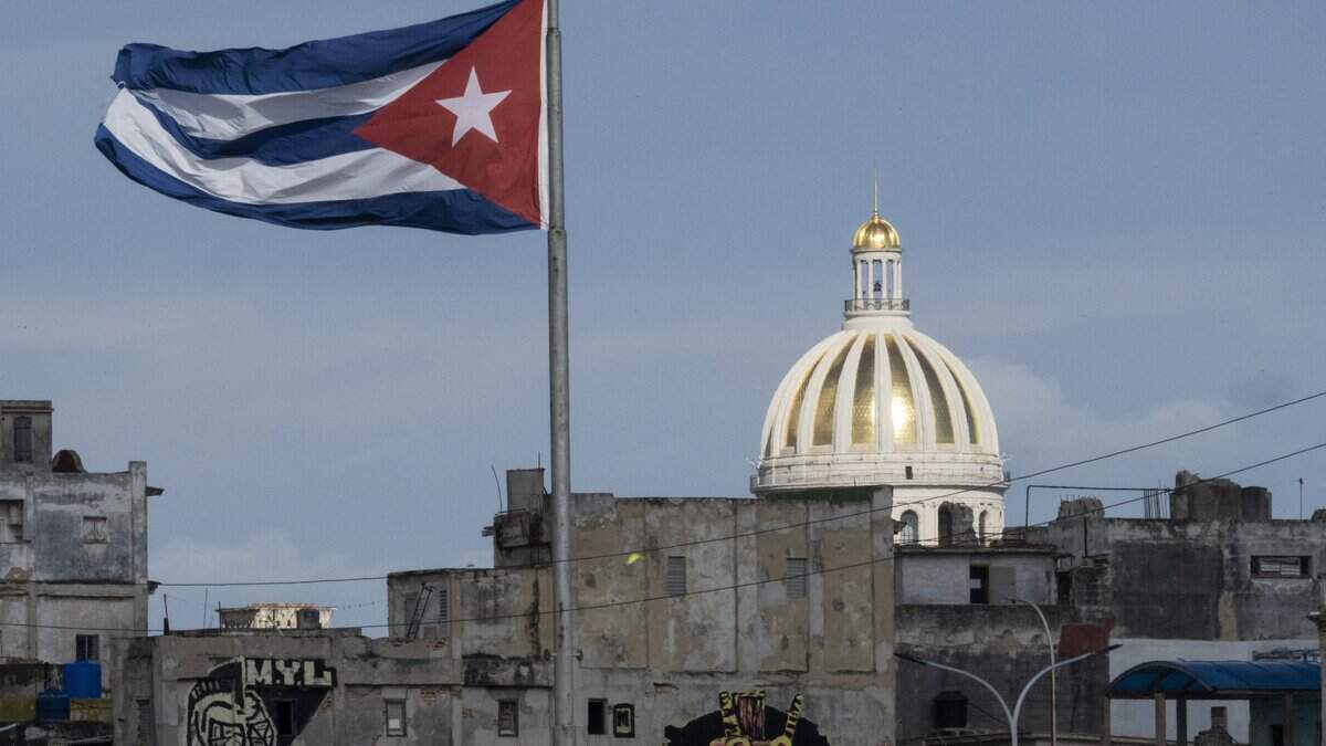 The Cuban flag flutters along the Malecon in Havana, with the Capitol seen in the background, on June 17, 2026. Senior leaders of Cuba's Communist Party met on June 17 to discuss reforms aimed at reviving a free-falling economy amid a US-imposed oil blockade on the island. (Photo by Pablo PORCIUNCULA / AFP via Getty Images)