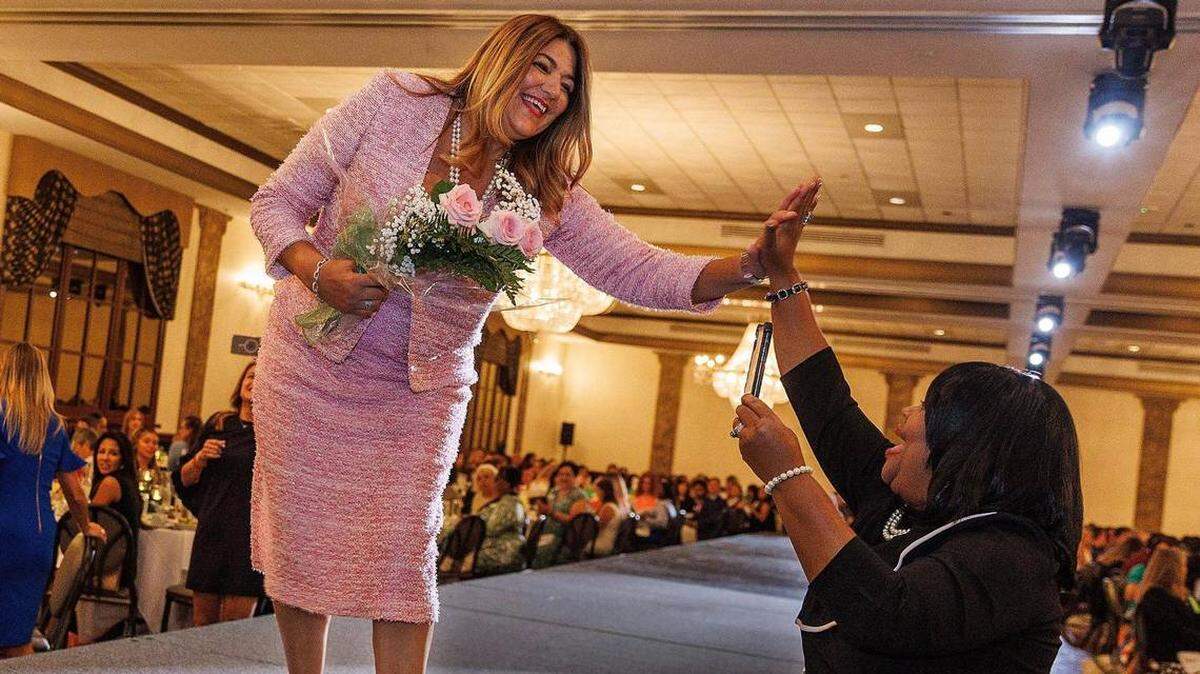 Madeline Pumariega, presidenta del Miami-Dade College, choca la mano tras recibir el premio Pionera Latina del Año, en la edición número 22 del almuerzo Destacadas Mujeres Hispanas, que tuvo lugar el viernes 25 de agosto de 2023, en Davie.