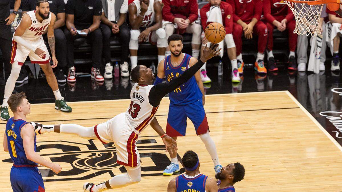 El jugador del Heat Bam Adebayo (centro) recibe una falta de Jeff Green, de los Nuggets de Denver, en el tercer partido de las Finales de la NBA, celebrado el 7 de junio de 2023 en Miami.