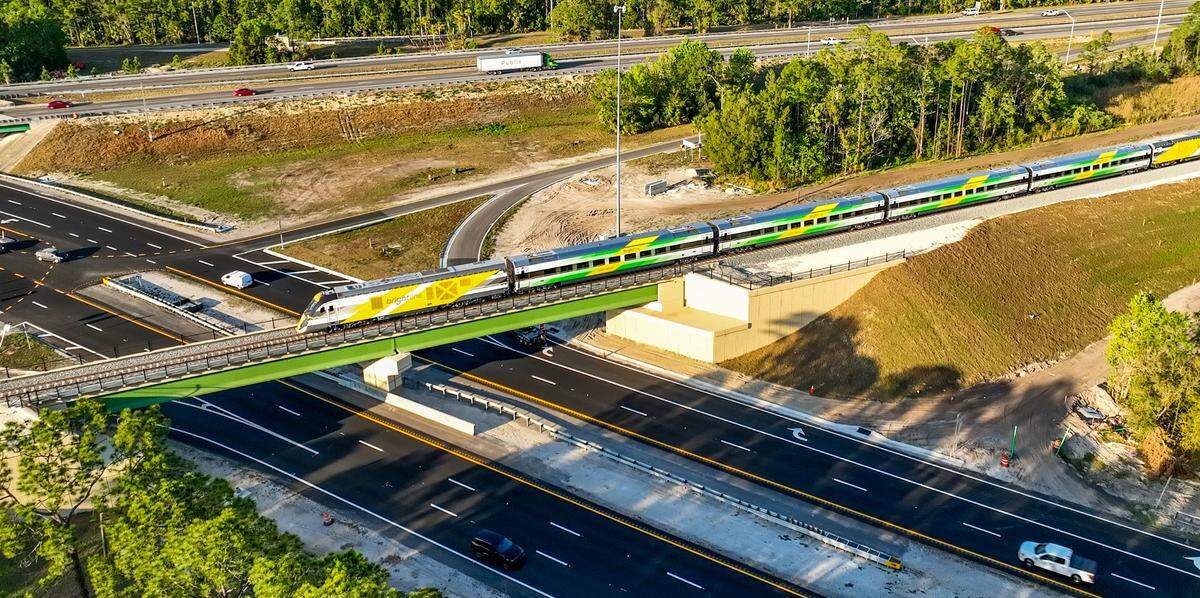 Un tren de Brightline cruza un puente en Florida Central a lo largo de la carretera estatal 528. El tramo de 56 kilómetros entre Cocoa y Orlando está separado a desnivel, sin cruces a nivel de calle.