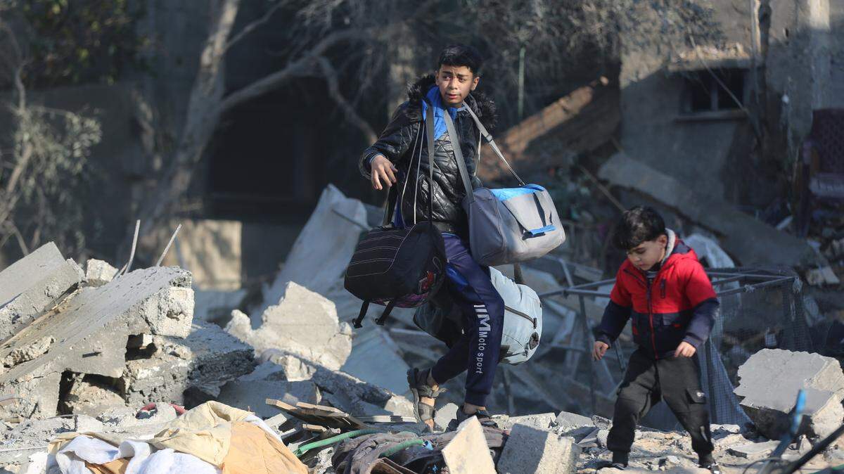 Dos niños buscan objetos de valor entre los escombros en una residencia destruida por un ataque israelí, el domingo 31 de diciembre de 2023, en el campo de refugiados Al-Maghazi, en el centro de Gaza.