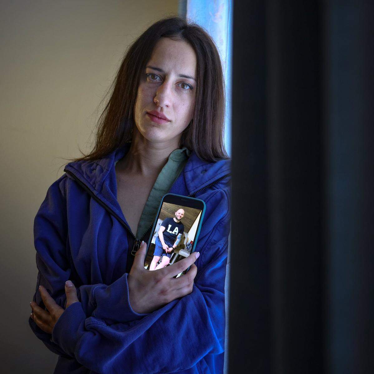 Oksana Tarasiuk sostiene una foto de su difunto compañero, Maksym Chernyak, quien falleció trágicamente bajo custodia de ICE el 16 de abril de 2025, en Hallandale Beach, Florida. 