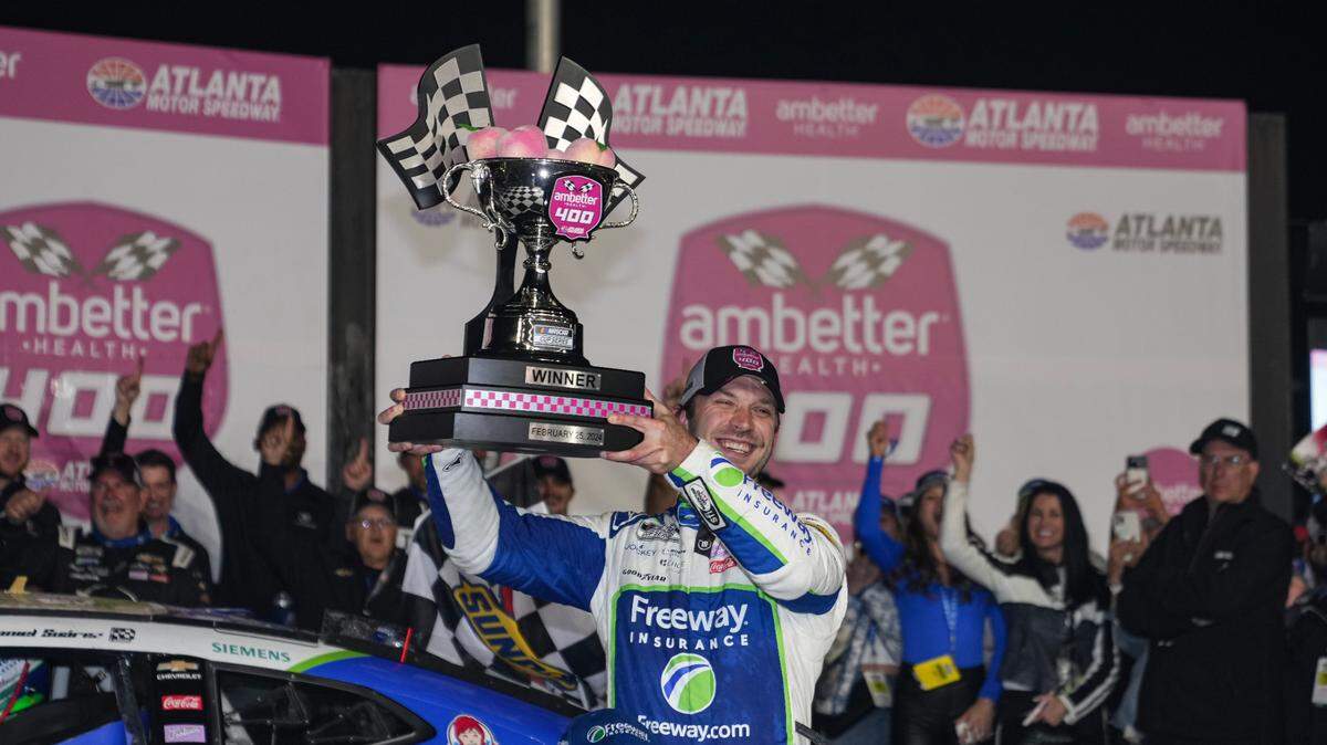 El mexicano Daniel Suárez celebra con el trofeo tras ganar la Ambether Health 400 de la Cup Series de NASCAR, en el Atlanta Motor Speedway en Atlanta, el domingo 25 de febrero de 2024.