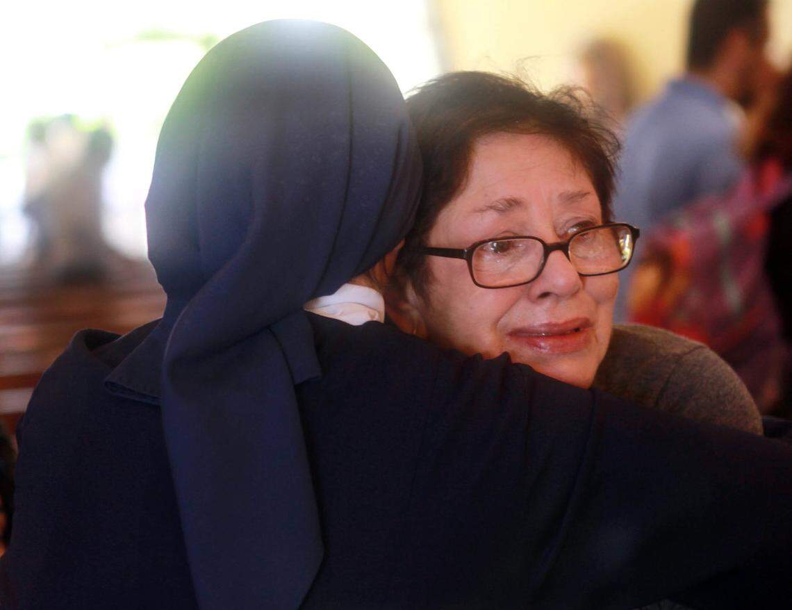 A nun consoles Iraida Román Martínez, sister of Monsignor Agustín Román, during the funeral services on Thursday, April 12, 2012, at the Shrine of Our Lady of Charity, following Monsignor Román’s passing.