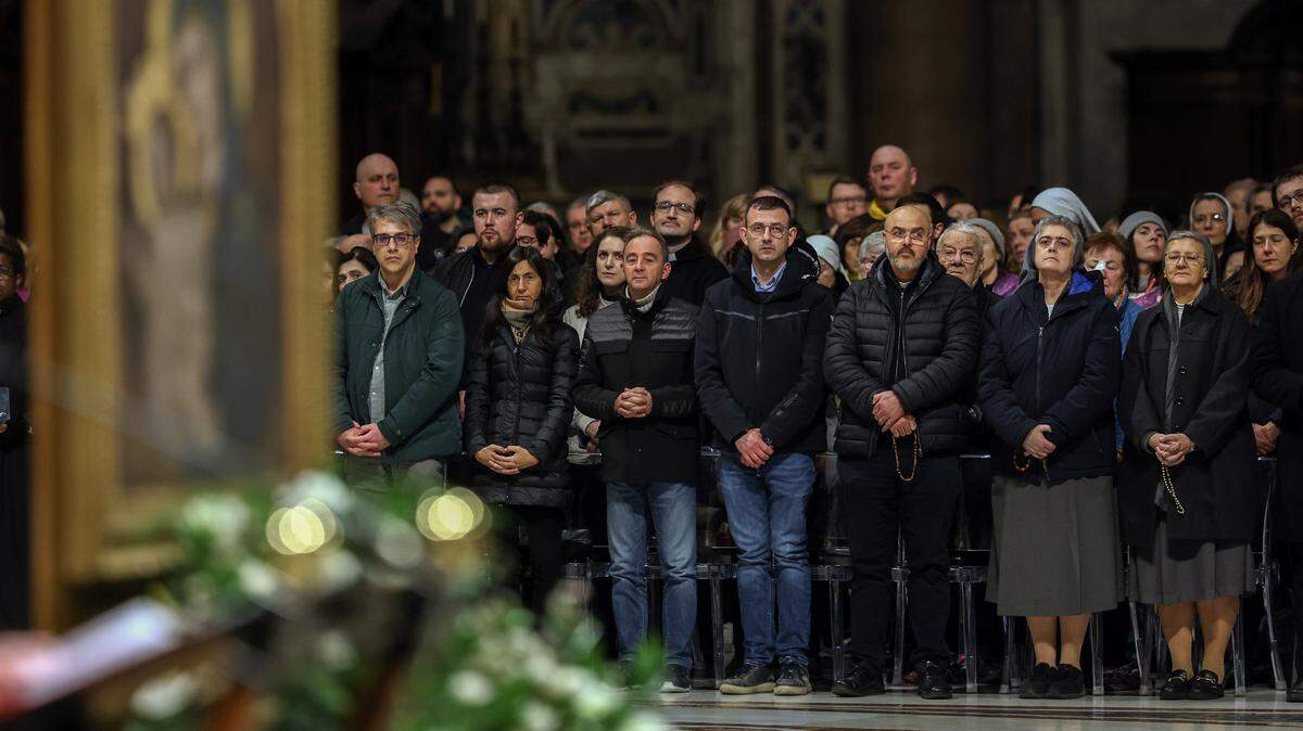 Decenas de personas asisten a la recitación del Rosario por la salud del papa Francisco, el sábado 1 de marzo de 2025, en la Basílica de San Pedro. El Papa ha estado hospitalizado desde el 14 de febrero.