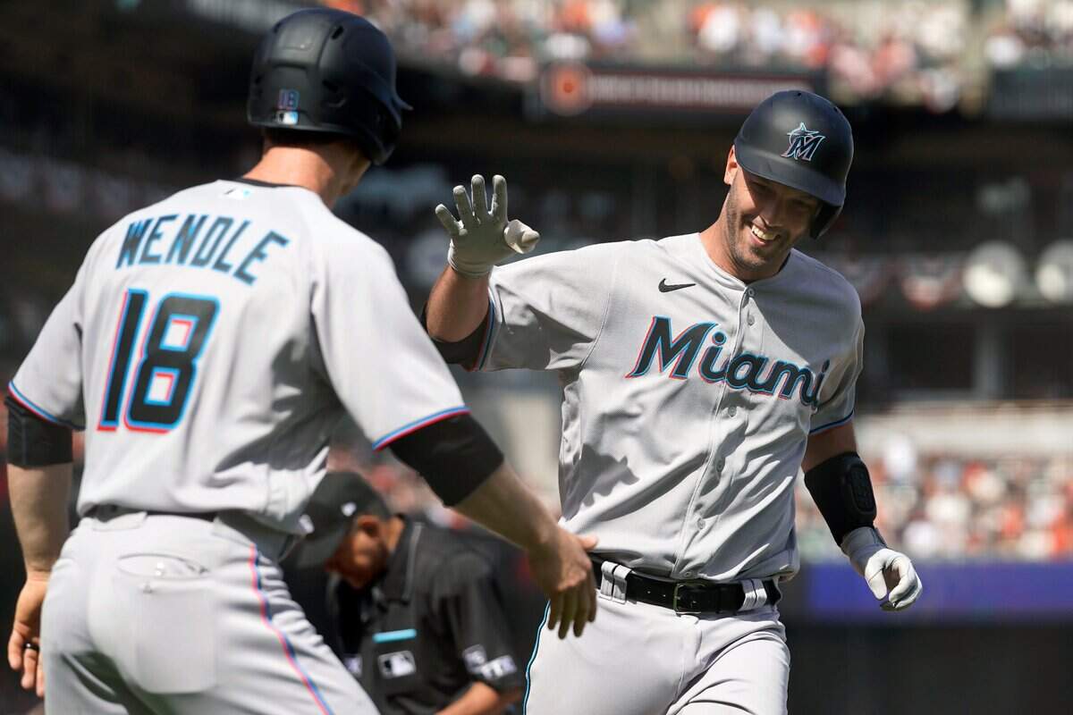 El catcher de los Marlins Jacob Stallings (der.) celebra tras pegar un jonrón en el séptimo inning del partido ante los Gigantes, el 8 de abril de 2022 en San Francisco.