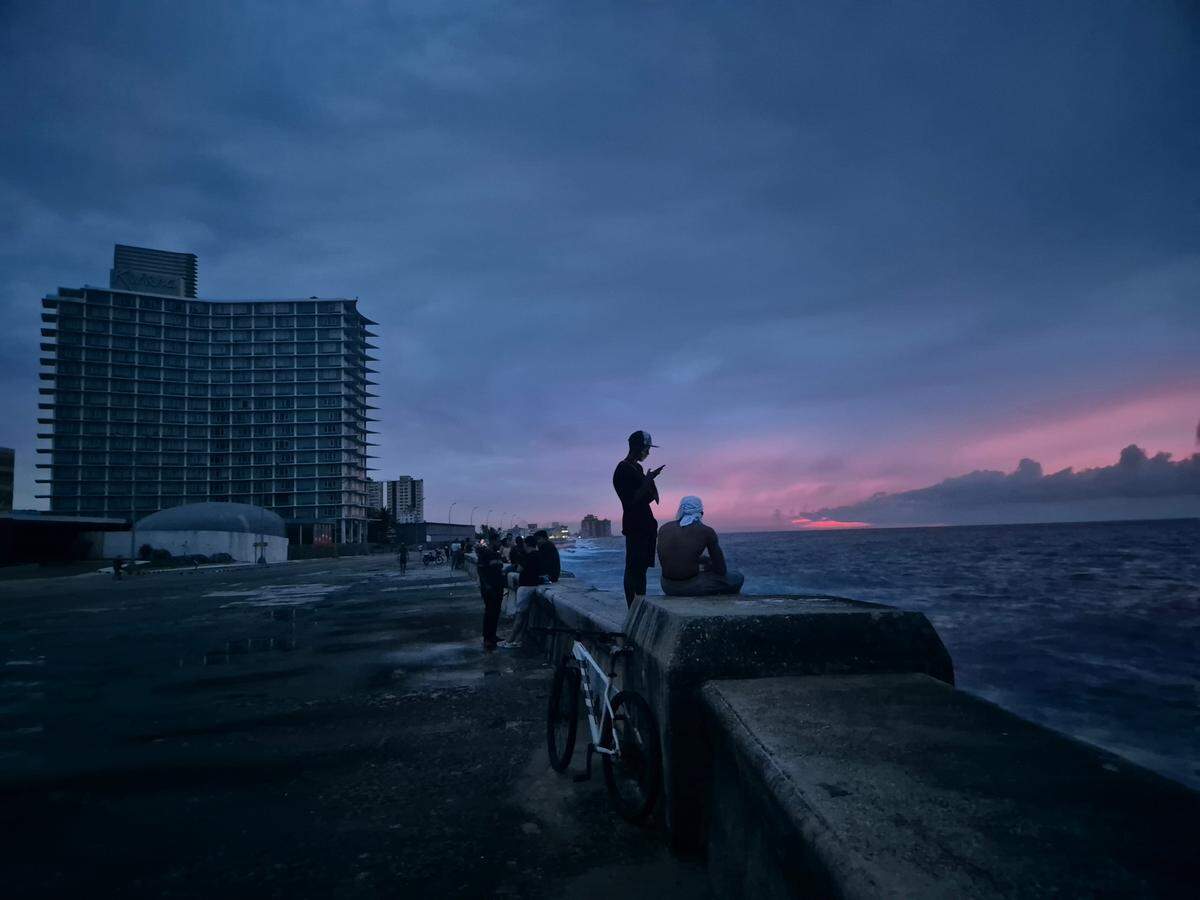 La gente se encuentra en el Malecón de La Habana, cerca del Hotel Habana Riviera, en la oscuridad después de que la red eléctrica de Cuba se cortara el viernes en toda la isla. Foto: Nick Kaiser/dpa/Sipa USA