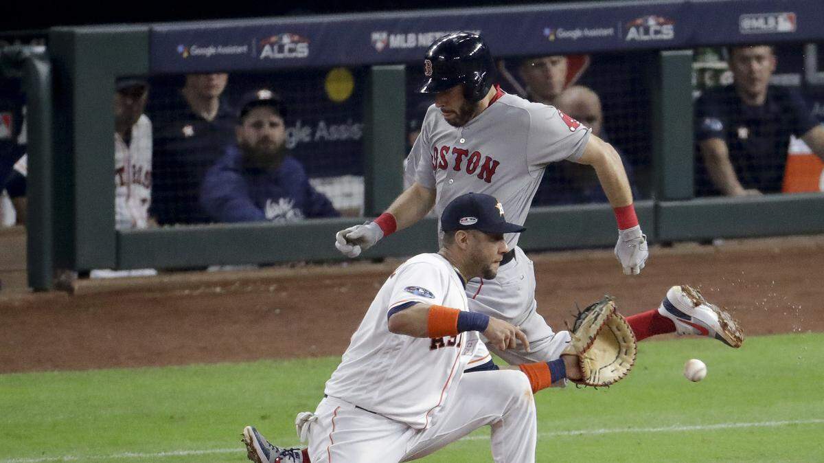 El primera base de los Astros Yuli Gurriel pone out a Ian Kinsler, de los Medias Rojas, en el quinto partido de la Serie de Campeonato de la Liga Americana, el 18 de octubre de 2018 en Houston.
