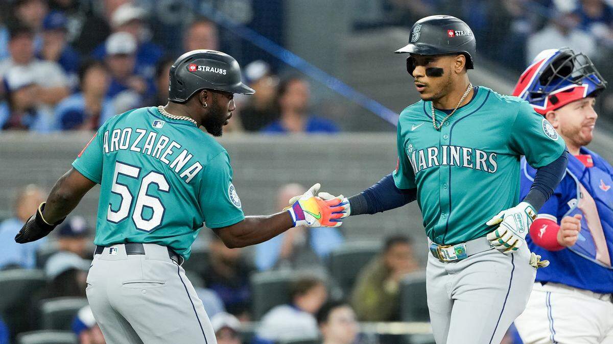 El segunda base de los Marineros de Seattle Jorge Polanco (der.) celebra con el jardinero Randy Arozarena tras pegar un jonrón de tres carreras ante los Azulejos, en el segundo partido de la Serie de Campeonato de la Liga Americana, efectuado el 13 de octubre de 2025 en Toronto.