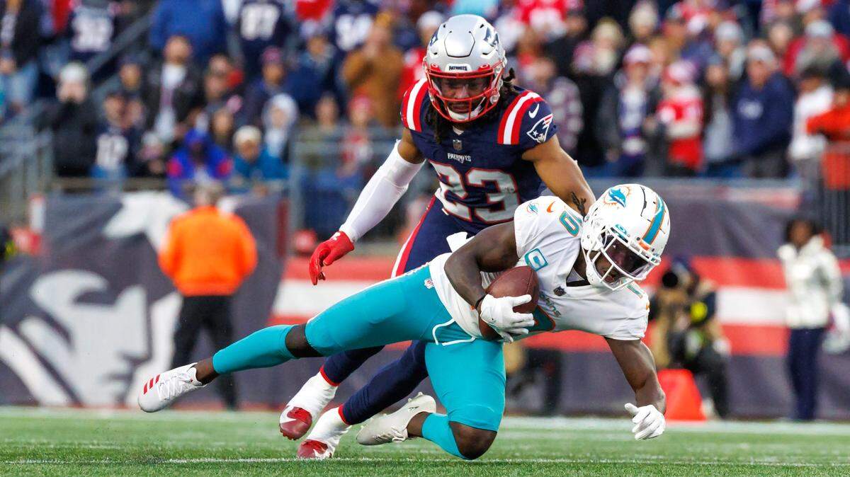 El wide receiver de los Dolphins Tyreek Hill (10) atrapa un pase ante la marca del safety de los Patriots, Kyle Dugger, en el partido celebrado el 1ro de enero de 2023 en Foxborough, Massachusetts.
