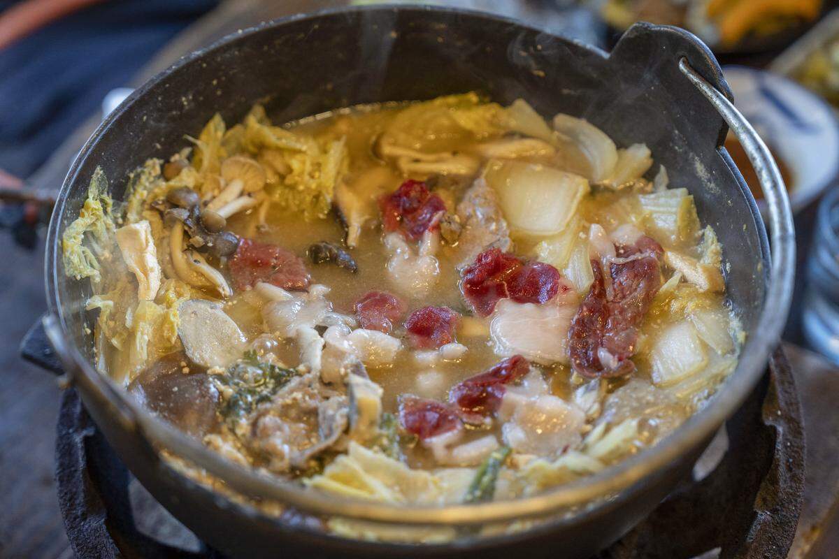 In this picture taken on December 12, 2025, bear meat hot pot is served at a restaurant in Chichibu, Saitama prefecture. Since Japan recorded a spike in deadly bear attacks, Koji Suzuki has struggled to keep up with booming demand for grilled cuts of the animal at his restaurant. Cooked on a stone slate -- or in hot pot with vegetables -- the meat comes from bears culled to curb maulings that have killed a record 13 people this year. (Photo by Yuichi YAMAZAKI / AFP via Getty Images) / To go with 'JAPAN-ENVIRONMENT-BEAR-FOOD' by Kyoko Hasegawa and Hiroshi Hiyama in Sapporo