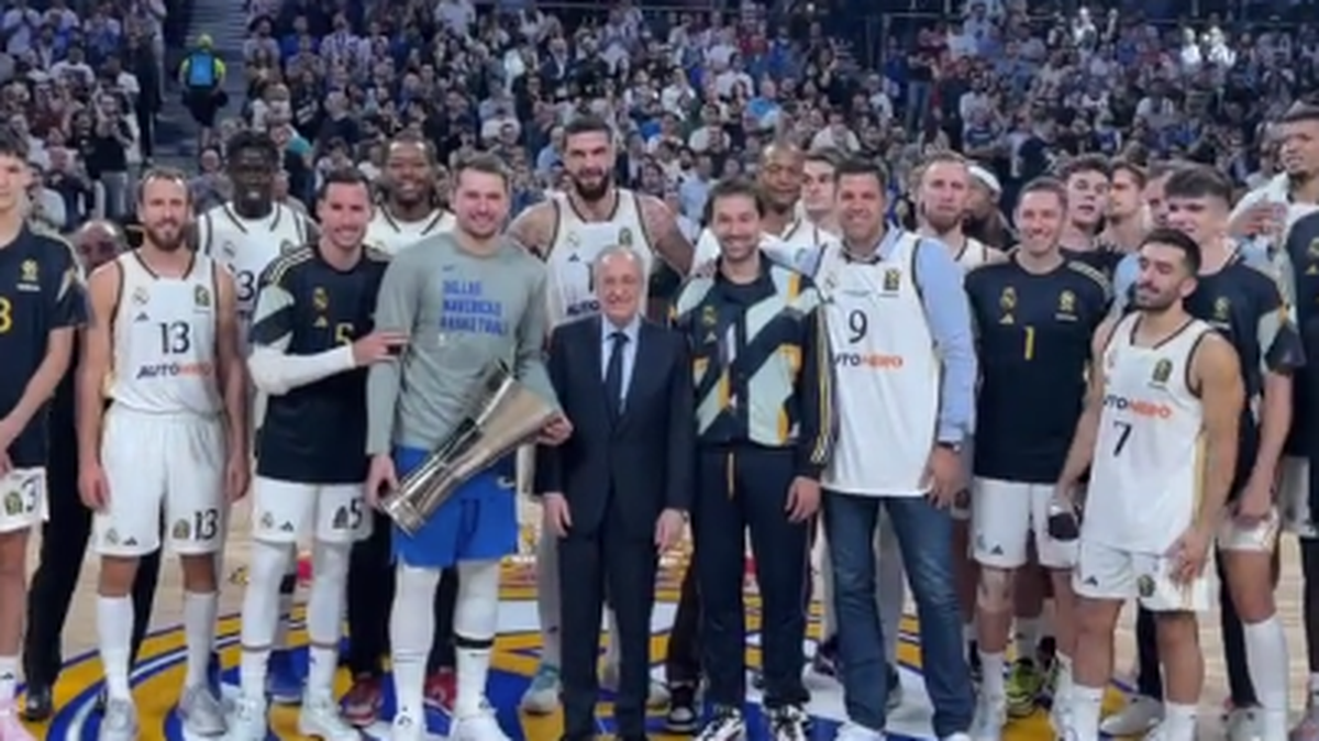 El jugador de los Mavericks de Dallas Luka Doncic (con el trofeo) y el presidente del club de fútbol Real Madrid Florentino Pérez posan con el equipo de basquetbol del mismo nombre antes de un partido amistoso, celebrado el 10 de octubre de 2023 en la capital española.  