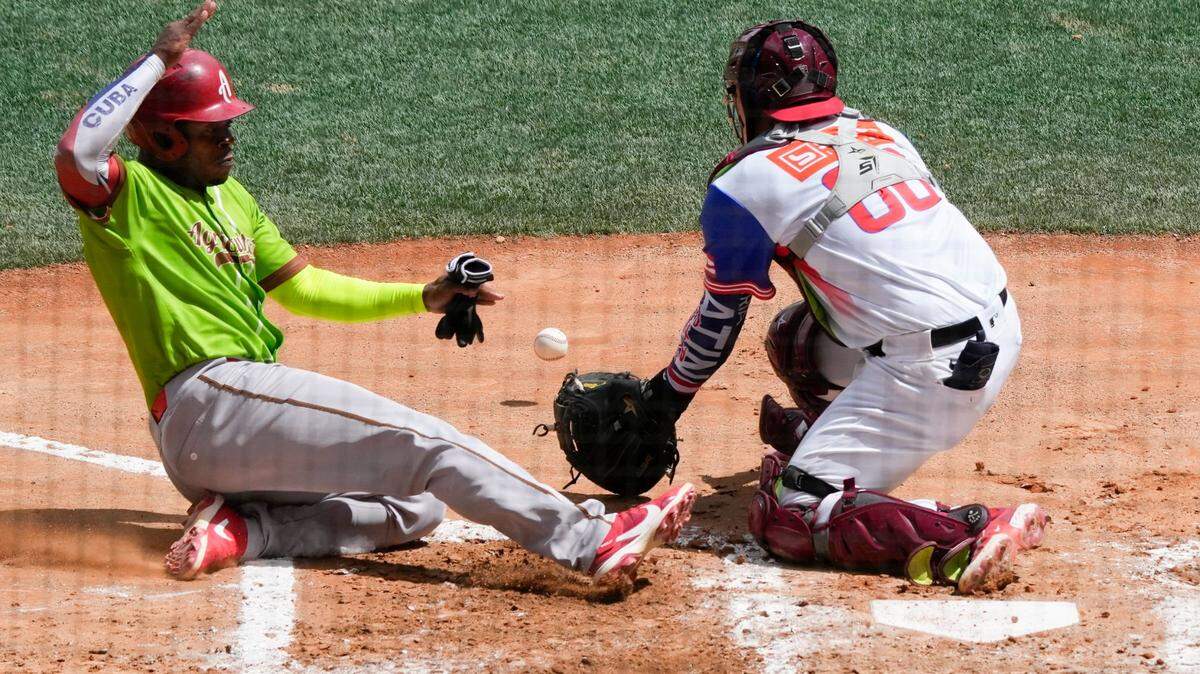 El pelotero cubano Yosvany Alarcón anota una carrera en la jugada con el receptor de Puerto Rico Brian Navarreto, en el segundo inning del partido de la Serie del Caribe celebrado el 7 de febrero de 2023 en Caracas, Venezuela.