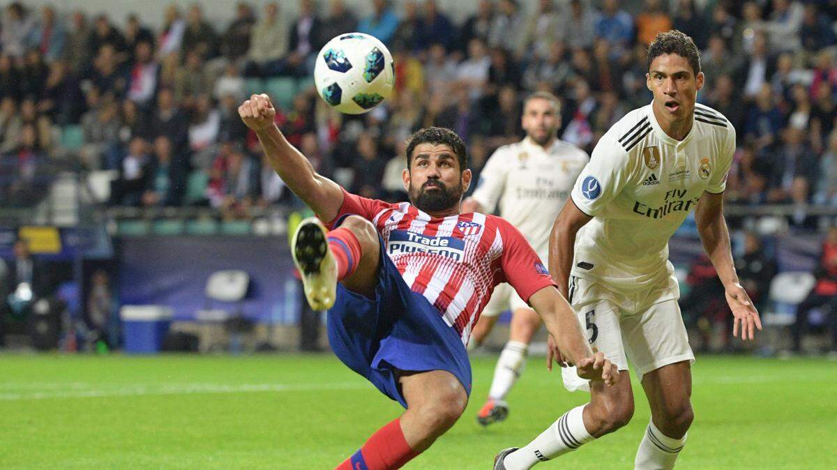 El jugador del Atlético Diego Costa (izq.) patea la pelota ante la marca de Raphael Varane, del Real Madrid, en el partido de la Supercopa de Europa celebrado el 15 de agosto de 2018 en Tallín, Estonia.