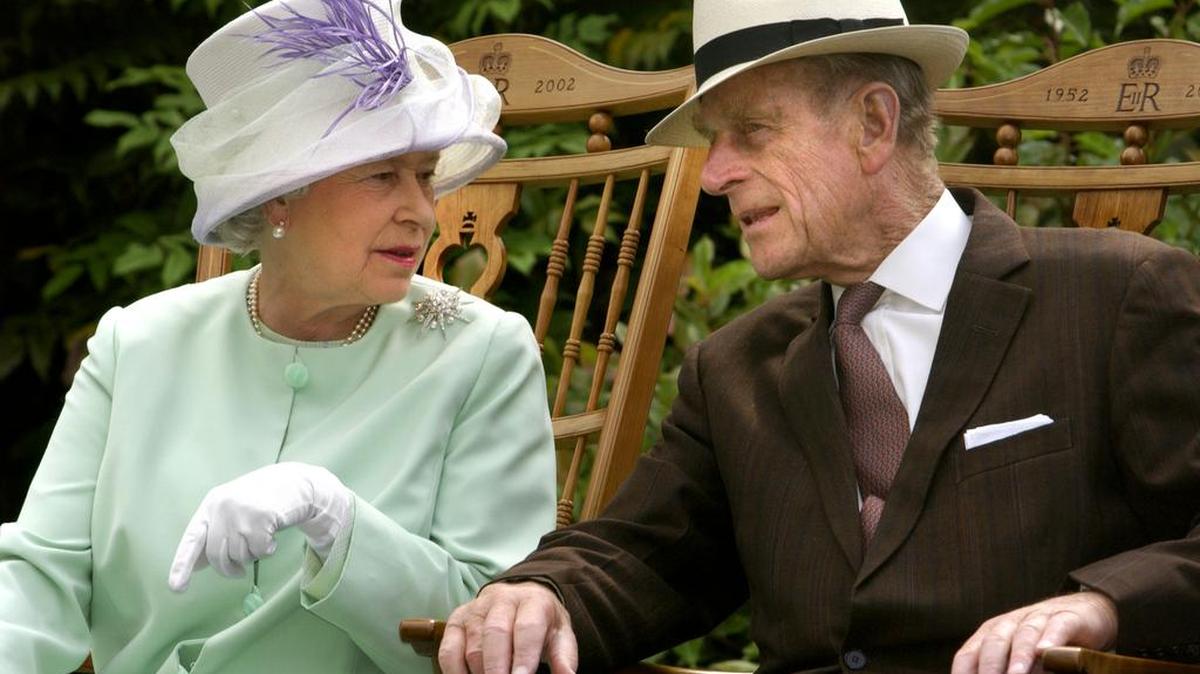 La Reina Isabel II y el Duque de Edimburgo hablando mientras estaban sentados durante una actuación musical en Abbey Gardens, Bury St Edmunds durante su visita del Jubileo de Oro a Suffolk. Foto fechada el 17/7/2002