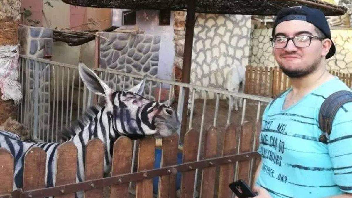 Fotografía compartida por un estudiante junto a la burra pintada como cebra. y que se volvió viral en las redes sociales.
