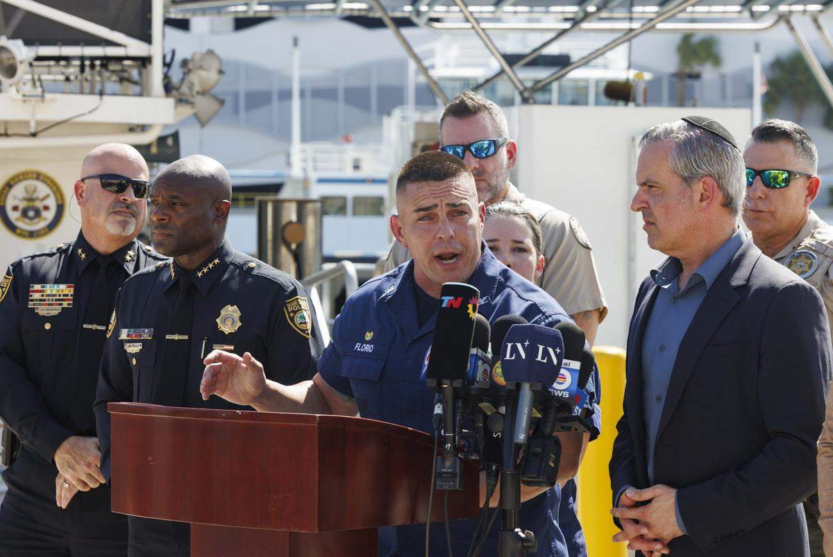 El capitán Frank Florio III, comandante del Sector Miami de la Guardia Costera (centro), habla durante una conferencia de prensa el martes 29 de julio de 2025 en el Sector Miami de la Guardia Costera en Miami Beach, donde ofrece información actualizada sobre la respuesta a la colisión de Hibiscus Island.