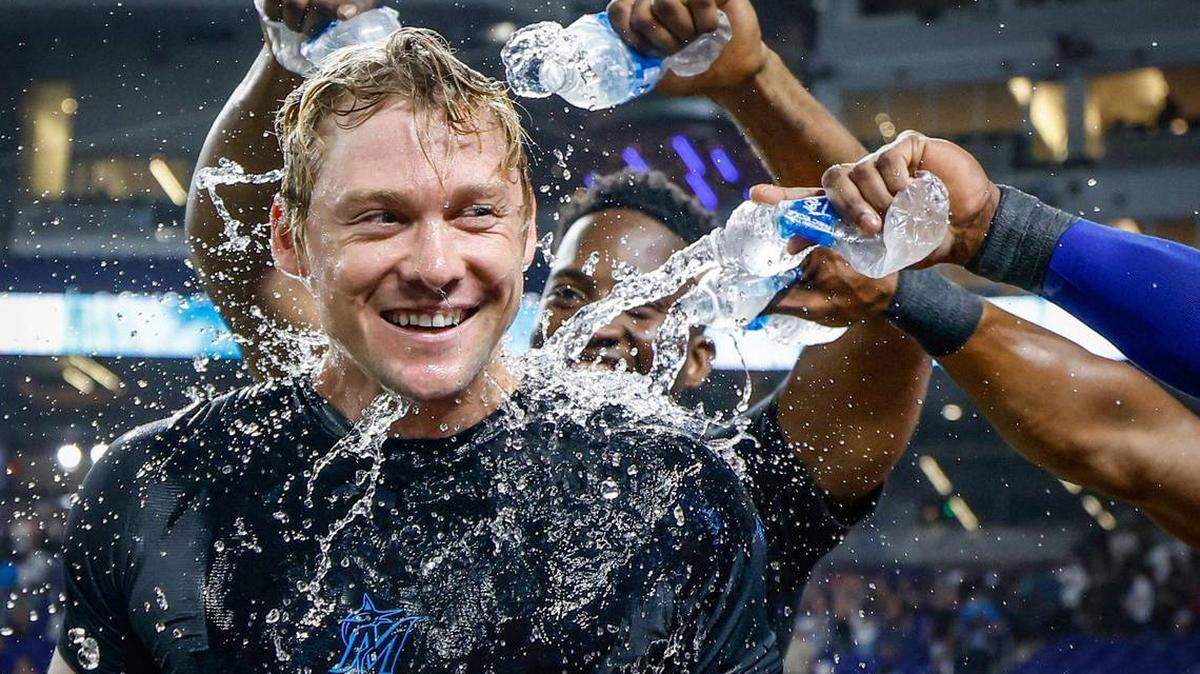 Compañeros de equipo de los Miami Marlins bañan a Kyle Stowers (28) después del juego después de batear un jonrón en una bola de fly al jardín derecho trayendo a Javier Sanoja (46) para anotar en la décima entrada contra los Reales de Kansas City en loanDepot park en Miami, Florida, el viernes 18 de julio de 2025