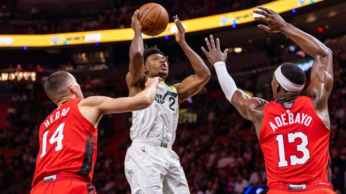 El amador del Utah Jazz, Collin Sexton (2), lanza sobre el defensa del Miami Heat, Tyler Herro (14), y el pívot Bam Adebayo (13) durante la primera mitad de un partido de la NBA en el Kaseya Center el sábado 4 de enero de 2025, en Miami, Florida.