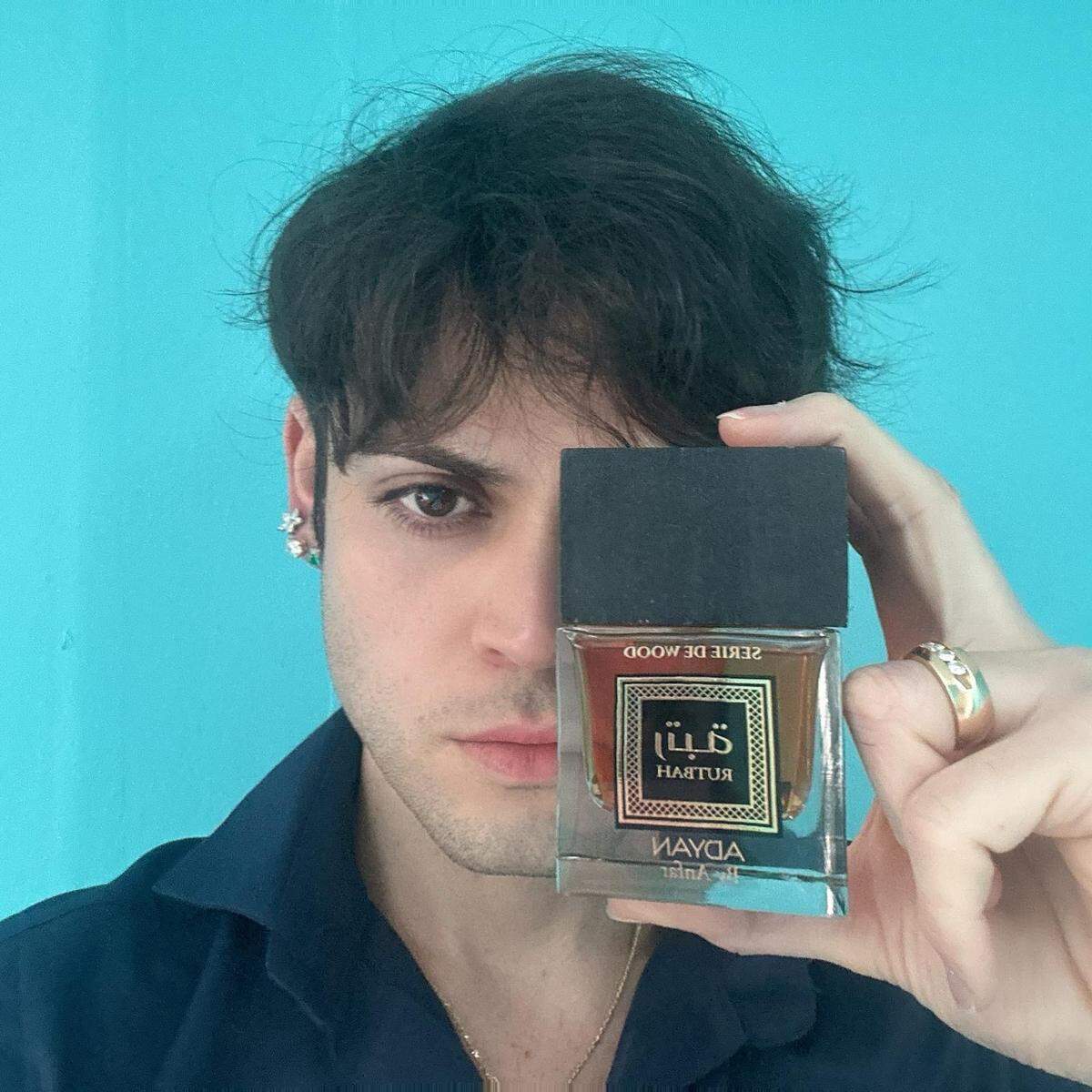 Jason Fonseca, Director Creativo de Ezenzia, con un perfume Rutbah.