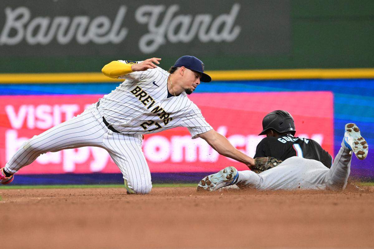 El torpedero de los Cerveceros Willy Adames (izq.) pone out a al jardinero de los Marlins Nick Gordon, en una jugada en el cuarto inning del partido celebrado el 28 de julio de 2024 en Milwaukee.