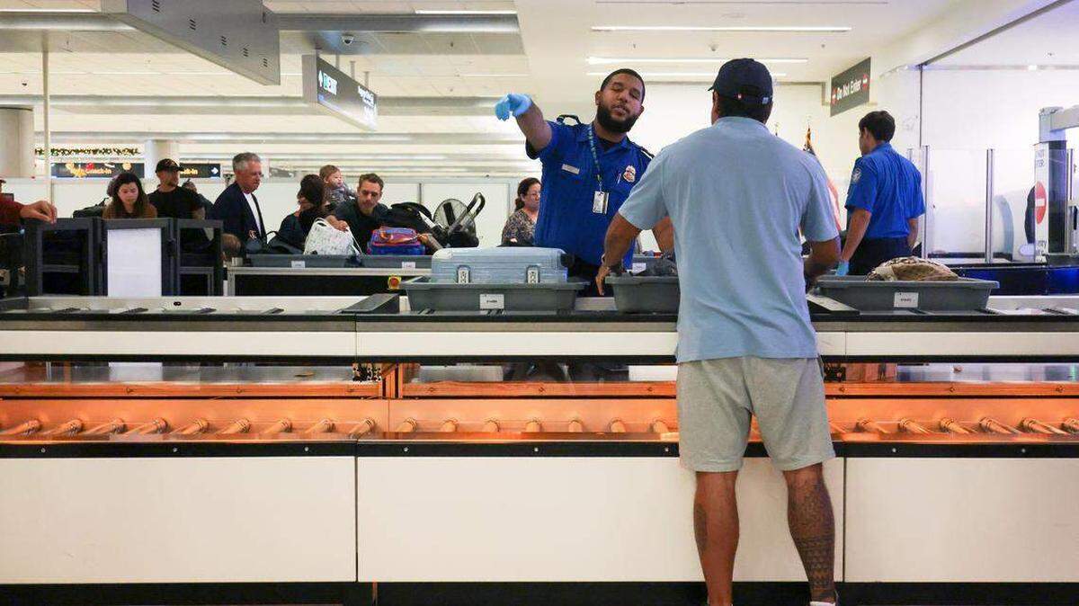 Un agente de la TSA guía a un viajero durante un control de seguridad en el Aeropuerto Internacional de Miami (MIA). Desde el 1 de febrero, pasajeros sin REAL ID podrían enfrentar verificación con TSA ConfirmID y una tarifa de $45 en vuelos nacionales.