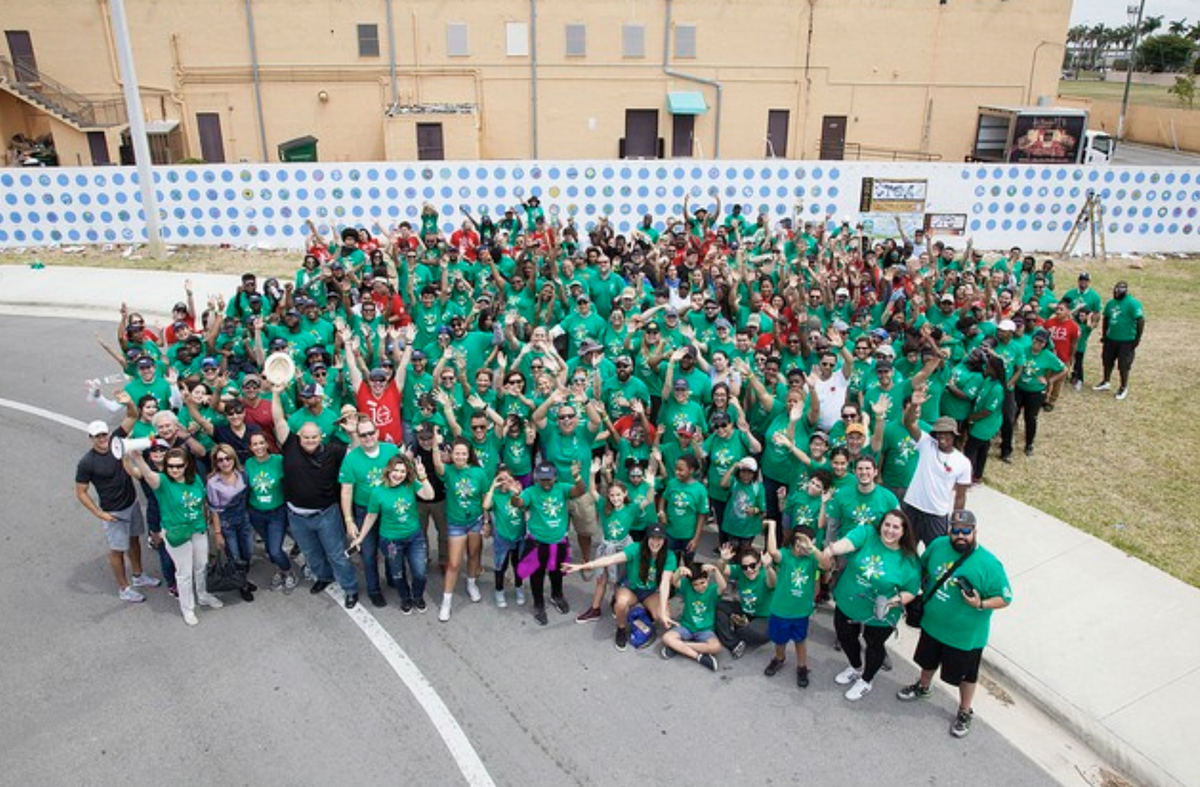MCortada y más de 300 voluntarios de la ciudad de Sweetwater celebran un nuevo mural que pintaron en Sweetwater Elementary en mayo del 2018.ás de 300 voluntarios se ven posando delante de un mural nuevo en Sweetwater Elementary.