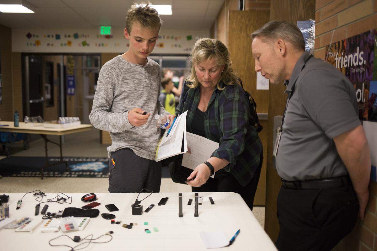 Un estudiante de octavo grado y su madre observan los distintos cigarrillos electrónicos que le han sido confiscados a estudiantes en Nevin Platt Middle School en Boulder, Colorado.