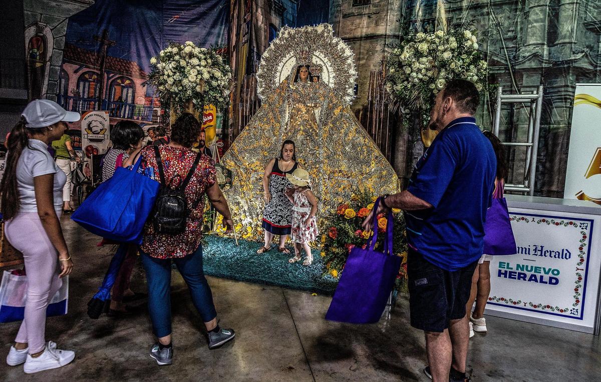 Visitantes posan con una representación artística de la Virgen de la Caridad, la Patrona de Cuba.