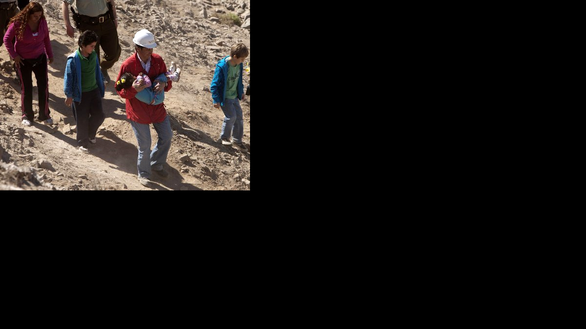 Foto de archivo. El ahora ex ministro chileno de Minería, Laurence Golborne (2d), carga una niña en brazos durante una ceremonia realizada en el yacimiento San José, Chile, el domingo 5 de septiembre de 2010.