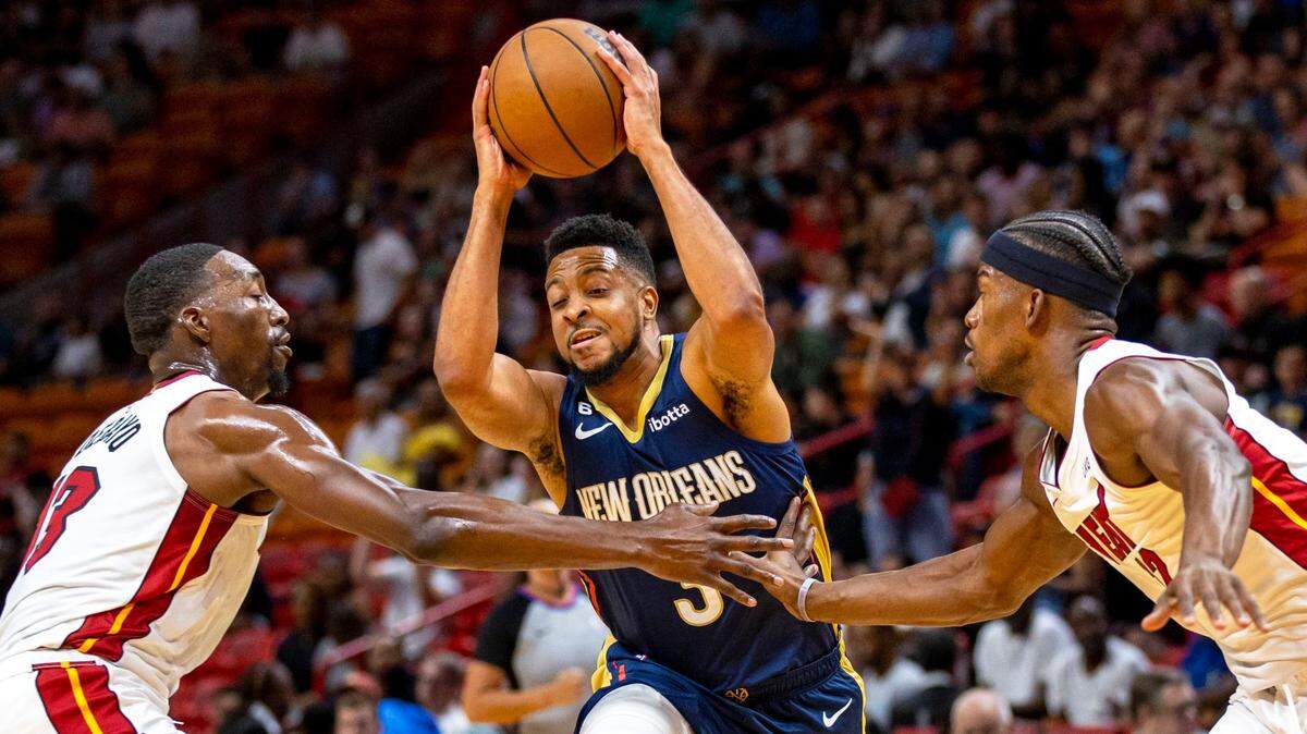 Los jugadores del Heat Jimmy Butler (izq.) y Bam Adebayo defienden ante el escolta de los Pelicans de New Orleans CJ McCollum, en el partido de pretemporada celebrado el 12 de octubre de 2022 en Miami.