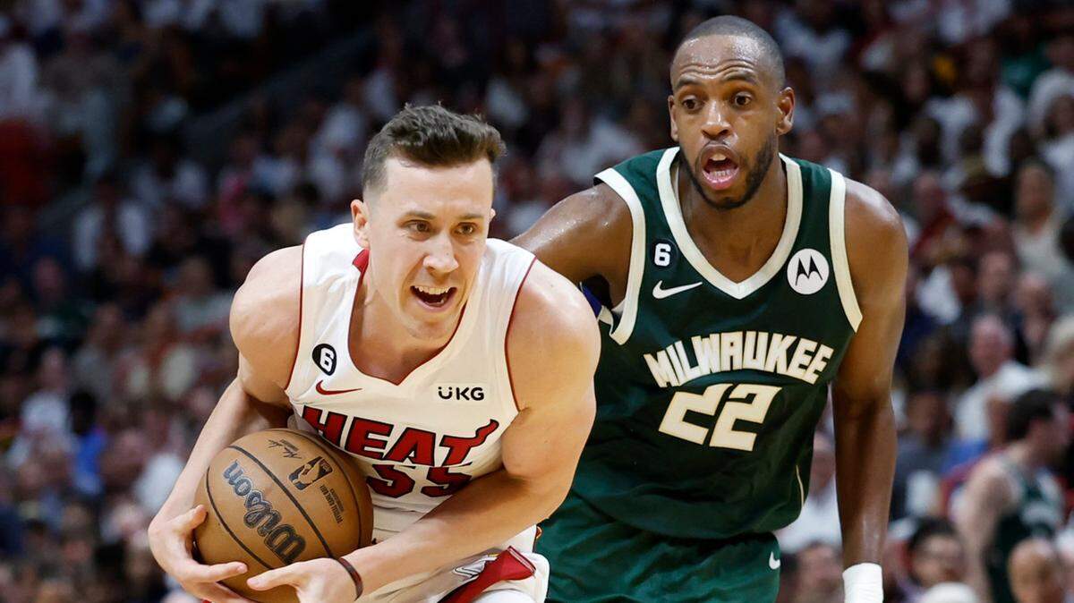 El jugador del Heat Duncan Robinson (izq.) trata de pasar la marca de Khris Middleton, de los Bucks de Milwaukee, en el tercer partido de la serie de playoffs, celebrado el 22 de abril de 2023 en Miami.