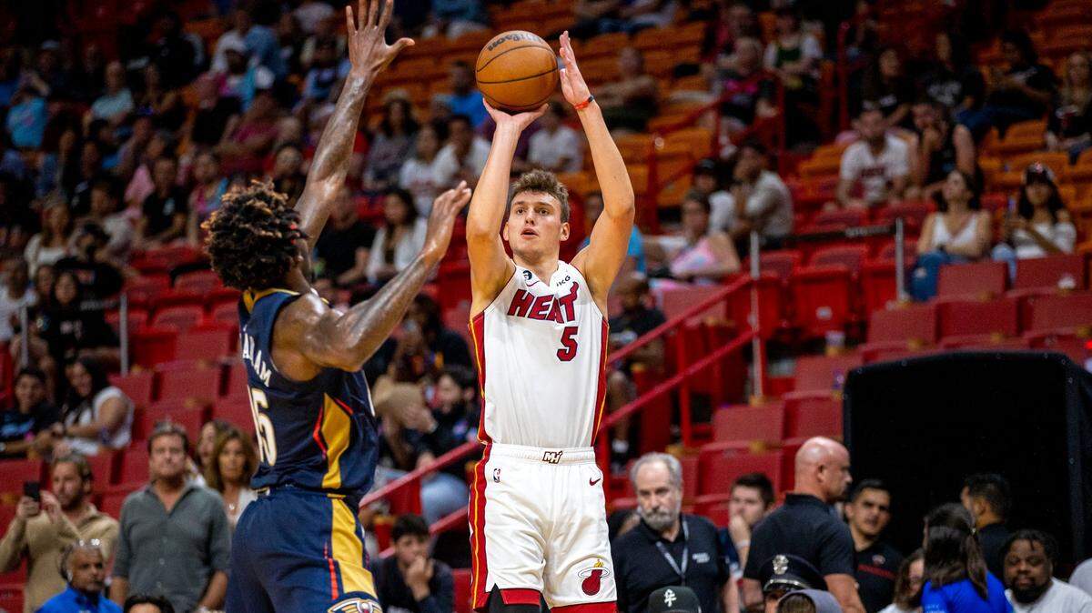 El jugador del Heat Nikola Jovic (5) tira al aro ante la marca de Zylan Cheatham, de los Pelicans de New Orleans, en el partido celebrado el 12 de octubre de 2022 en Miami.