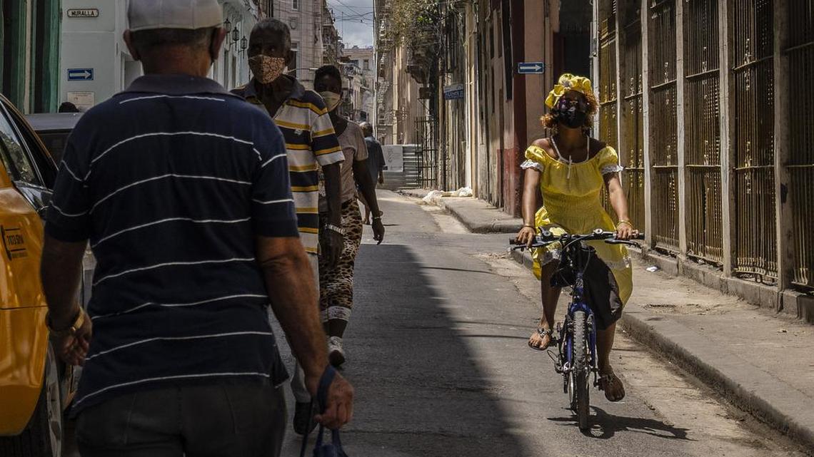 Una mujer, con una mascarilla protectora como medida de precaución contra la propagación del nuevo coronavirus, conduce su bicicleta por una calle de La Habana, Cuba, el miércoles 2 de junio de 2021.