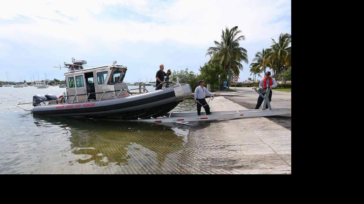 De izquierda a derecha, el mecánico de marina de Miami-Dade, Kurk Jablonski, el bombero de Miami-Dade Capitán Carlos Giménez, y el bombero de Miami-Dade Scott Walker sacan el pequeño barco del agua y dejan los barcos grandes en preparación para la tormenta tropical Erika, en Watson Island Marina el viernes 28 de agosto, 2015, en Miami.

