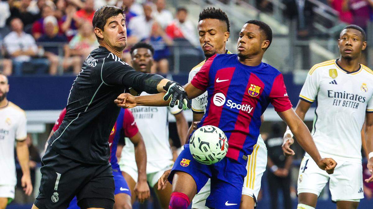 El portero del Real Madrid, Thibaut Courtois (izq.), trata de evitar el remate del delantero del Barcelona Ansu Fati, en el Clásico disputado en el estadio AT&T en Arlington, Texas, el 29 de julio de 2023.