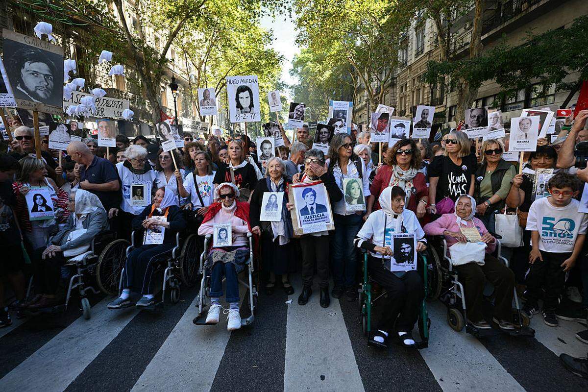 Miembros de la asociación de derechos humanos Madres de Plaza de Mayo sostienen los retratos de sus hijos e hijas desaparecidos al llegar a la Plaza de Mayo, en el 50.º aniversario del inicio de la última dictadura militar (1976-1983), en Buenos Aires, el martes 24 de marzo de 2026.