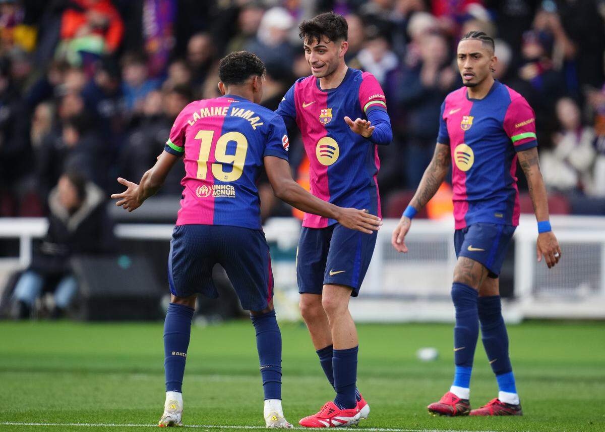 Los jugadores de Barcelona Lamine Yamal, Pedri y Raphinha (de izq. a der) celebran un gol ante el Deportivo Alavés  en la liga española, en el partido celebrado el 2 de enero de 2024.