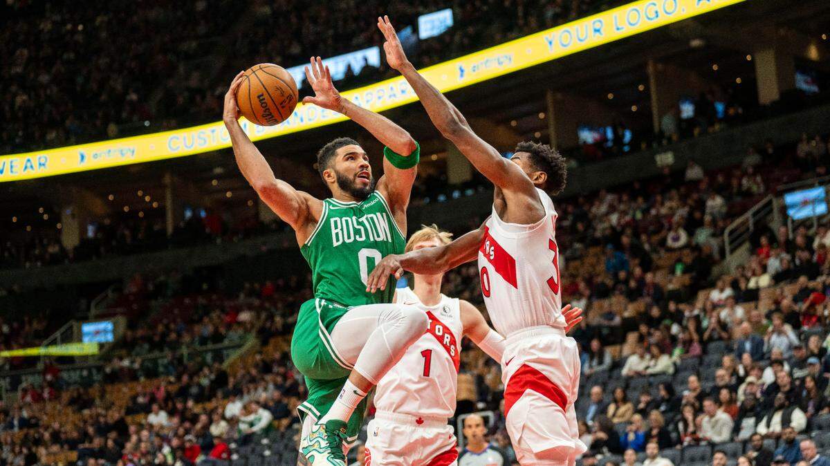 El astro de los Celtics de Boston Jayson Tatum (0) entra al aro ante la marca de Ochai Agbaji (30), de los Raptors, en el partido de pretemporada celebrado el 15 de octubre de 2024 en Toronto.