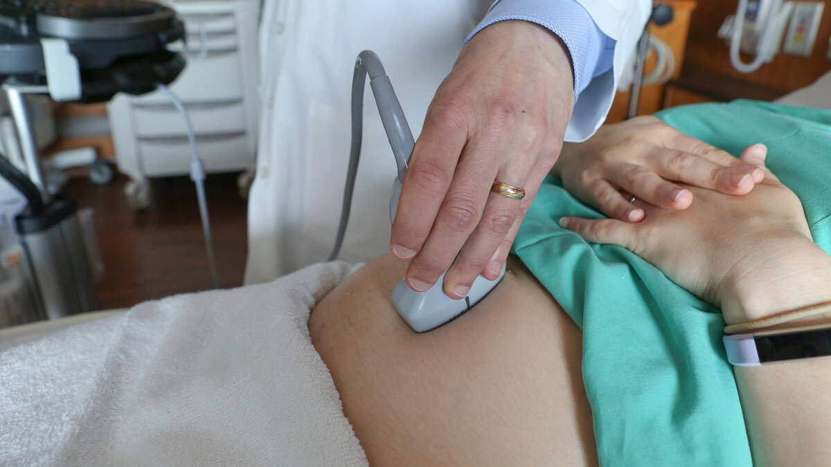 In this Aug. 7, 2018 photo, a doctor performs an ultrasound scan on a pregnant woman at a hospital in Chicago. According to a study released on Wednesday, Aug. 8, 2018, first-time mothers at low risk of complications were less likely to need a cesarean delivery if labor was induced at 39 weeks instead of waiting for it to start on its own. Their babies fared better, too. (AP Photo/Teresa Crawford)