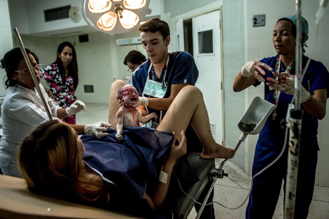 Un equipo médico de maternidad ayuda a parir a la bebé de Nataly Smith. Los médicos de hospitales públicos de Venezuela usualmente ganan menos de 10 dólares al mes.