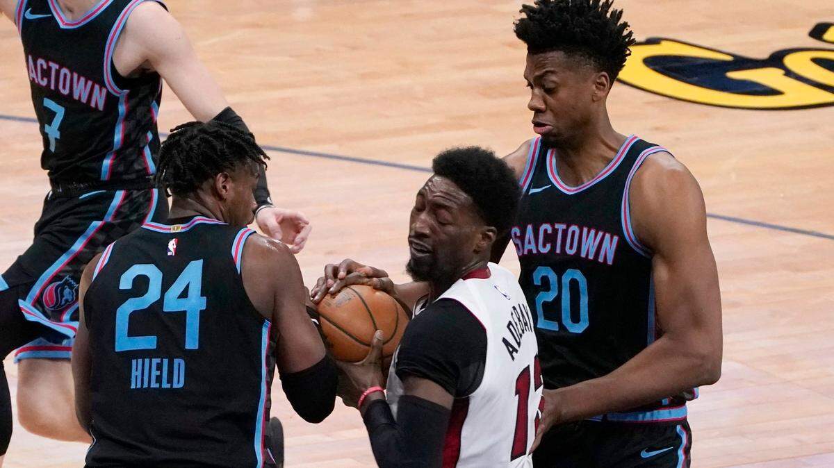 El jugador del Heat de Miami Bam Adebayo (centro) lucha por la pelota con Buddy Hield (izq.) y Hassan Whiteside, de los Kings, en el partido celebrado el 18 de febrero de 2021 en Sacramento.