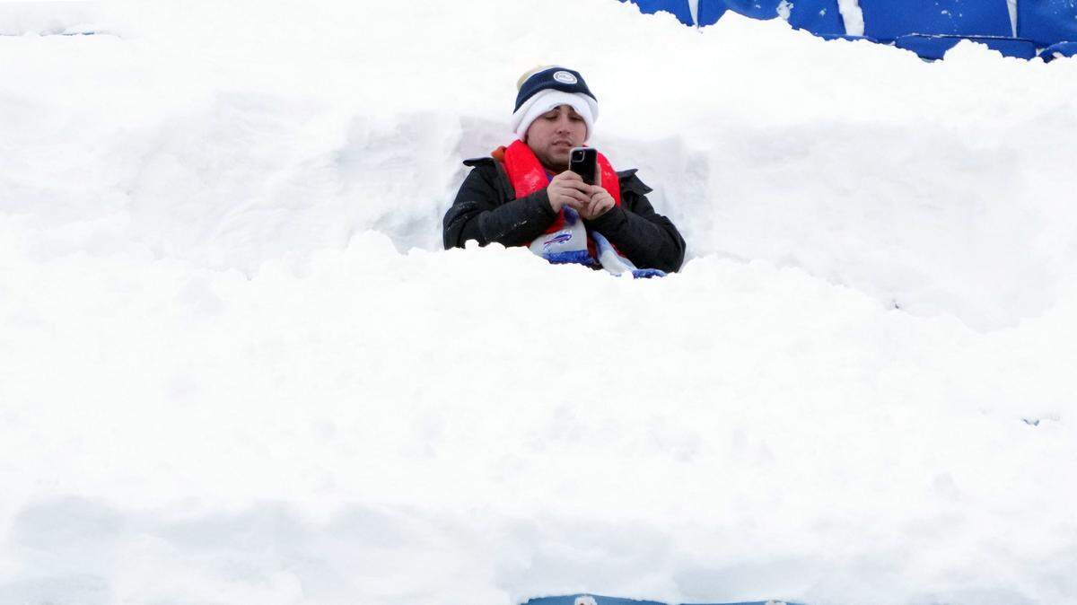 Un fanatico se sienta en la nieve durante el partido de futbol americano entre Pittsburgh Steelers y Buffalo Bills en el Estadio Highmark, en Orchard Park, Nueva York, el lunes 15 de enero de 2024.