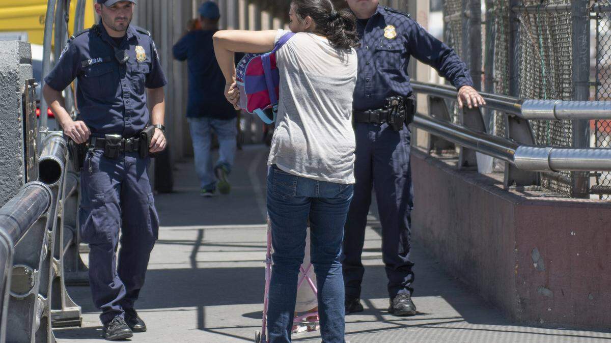 Agentes de la Oficina de Aduanas y Protección Fronteriza interrogan a personas en el Puente Internacional de El Paso, Nuevo México, el martes 19 de junio del 2018.