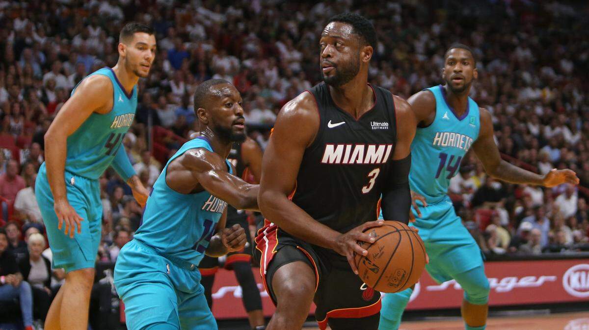 El escolta del Heat Dwyane Wade (#3) trata de pasar la pelota ante la marca de Kemba Walker, de los Hornets, en el primer cuarto del partido celebrado el 20 de octubre de 2018 en Miami.