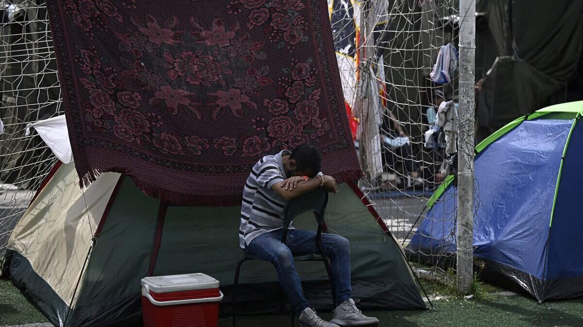 TOPSHOT - A man displaced following the June 24 twin earthquakes takes a nap on a chair in an improvised camp at the Jose Maria Vargas sports complex in Maiquetia, La Guaira state, Venezuela, on June 30, 2026. Tens of thousands of people urgently need food and shelter in Venezuela due to the devastation from two huge earthquakes that killed more than 1,700 and injured 5,000, the UN said on June 30, 2026, as doctors warned of potential outbreaks of disease. (Photo by Federico PARRA / AFP via Getty Images)