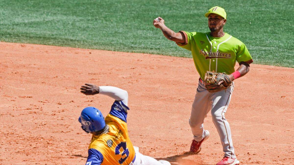 El torpedero de Cuba Andrés De La Cruz tira a primera base tras poner out en segunda al inicialista de Colombia Dilson Herrera, en una jugada de doble matanza en el partido de la Serie del Caribe celebrado el 6 de febrero de 2023 en Caracas, Venezuela.