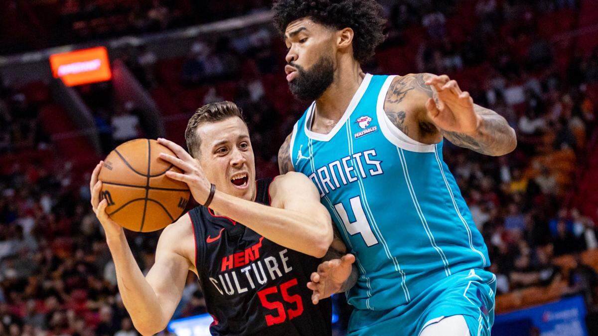 El delantero del Miami Heat, Duncan Robinson (55), conduce hacia el centro de los Charlotte Hornets, Nick Richards (4), durante la primera mitad de un partido de la NBA en el Kaseya Center en Miami, Florida, el miércoles 13 de diciembre de 2023. ​